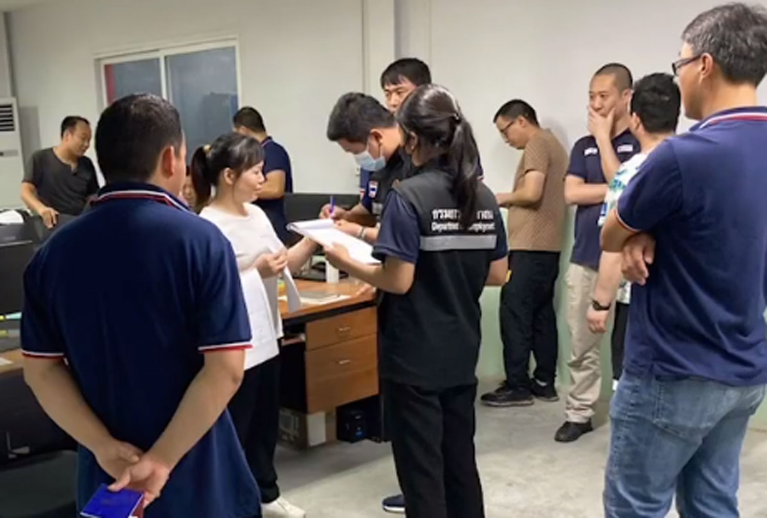 La policía de inmigración y funcionarios de la oficina de empleo provincial de Chon Buri inspeccionan una fábrica en el distrito de Ban Bung y arrestan a seis turistas chinos por trabajar allí ilegalmente.  (Capturado de un video de Si Racha Chon Buri Facebook)