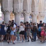 A group of tourists, part of them wearing facemasks, are pictured on St Mark's Square in Venice.