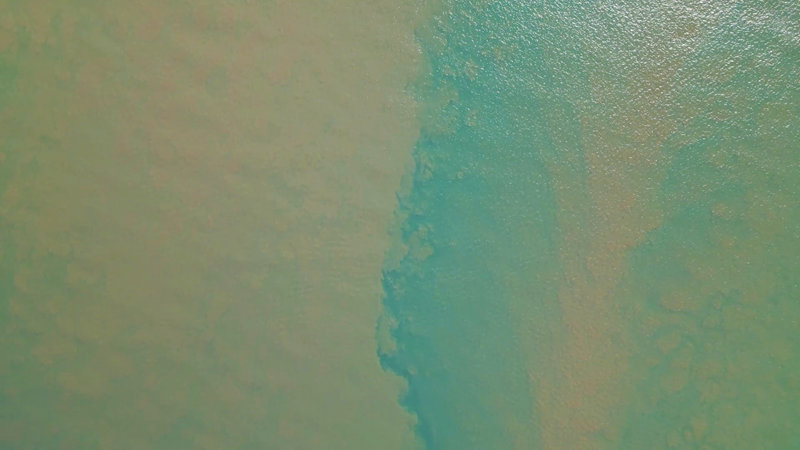 Una columna de sedimento marrón se mezcla con el agua azul del océano en Darmble Sea Country Capel Bay.