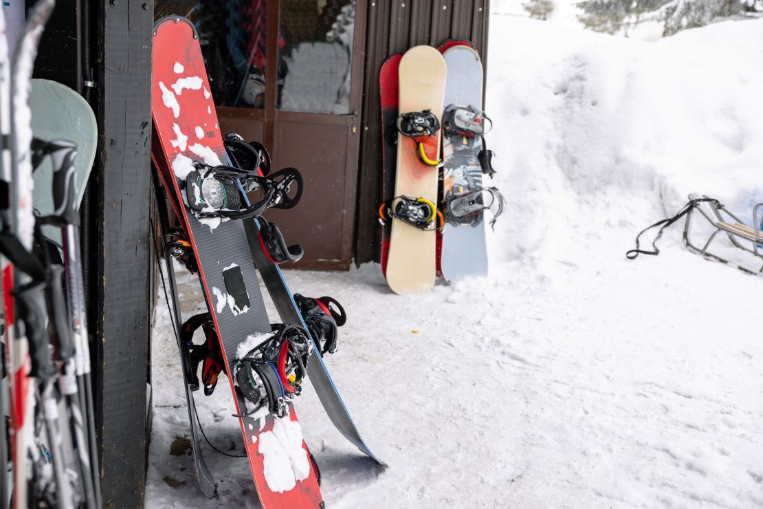 Imagen de varios equipos de esquí y snowboard en una estación de esquí.