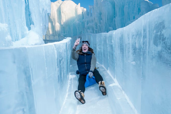 Un visitante del castillo de hielo desciende por un tobogán de hielo.