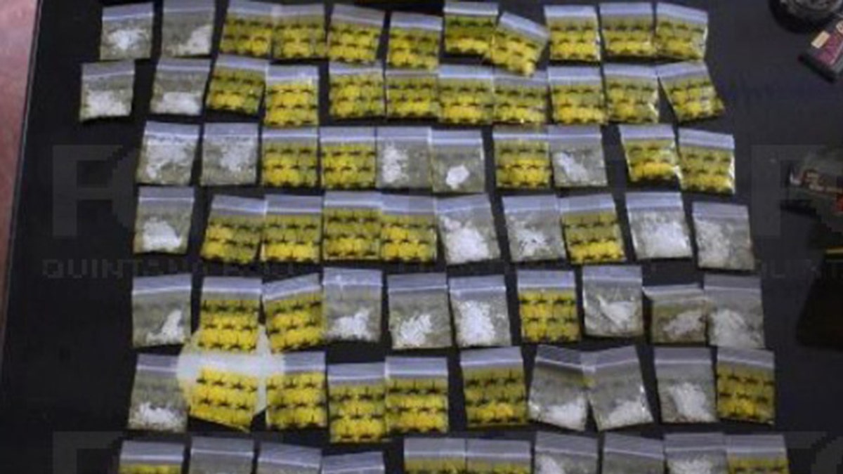 Sobre la mesa hay pequeñas bolsas amarillas y transparentes, llenas de sustancias como marihuana y metanfetamina.