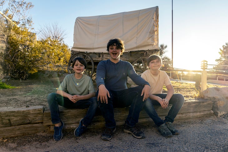 Tres niños exploran el set de una película del oeste en Indian Cliffs Ranch.