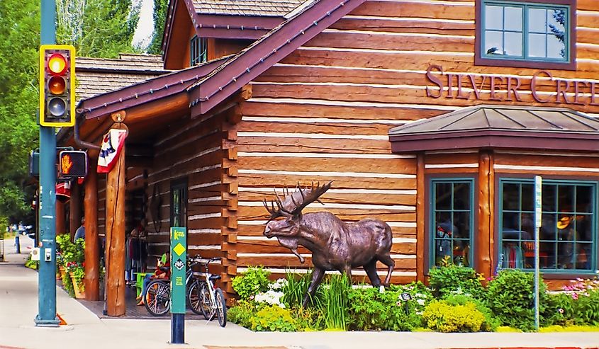 Esquina de la calle del centro de Ketchum Idaho con tienda de cabañas de madera y estatua de alce cerca de Sun Valley.