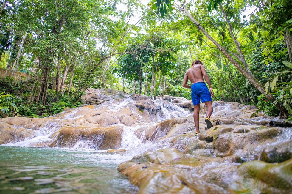 Un hombre pasa junto al río y la cascada de las dunas de Ocho Ríos.