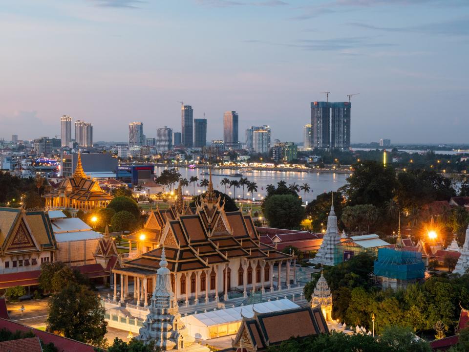 Ciudad con árboles, edificios y paseo marítimo al amanecer en un día claro