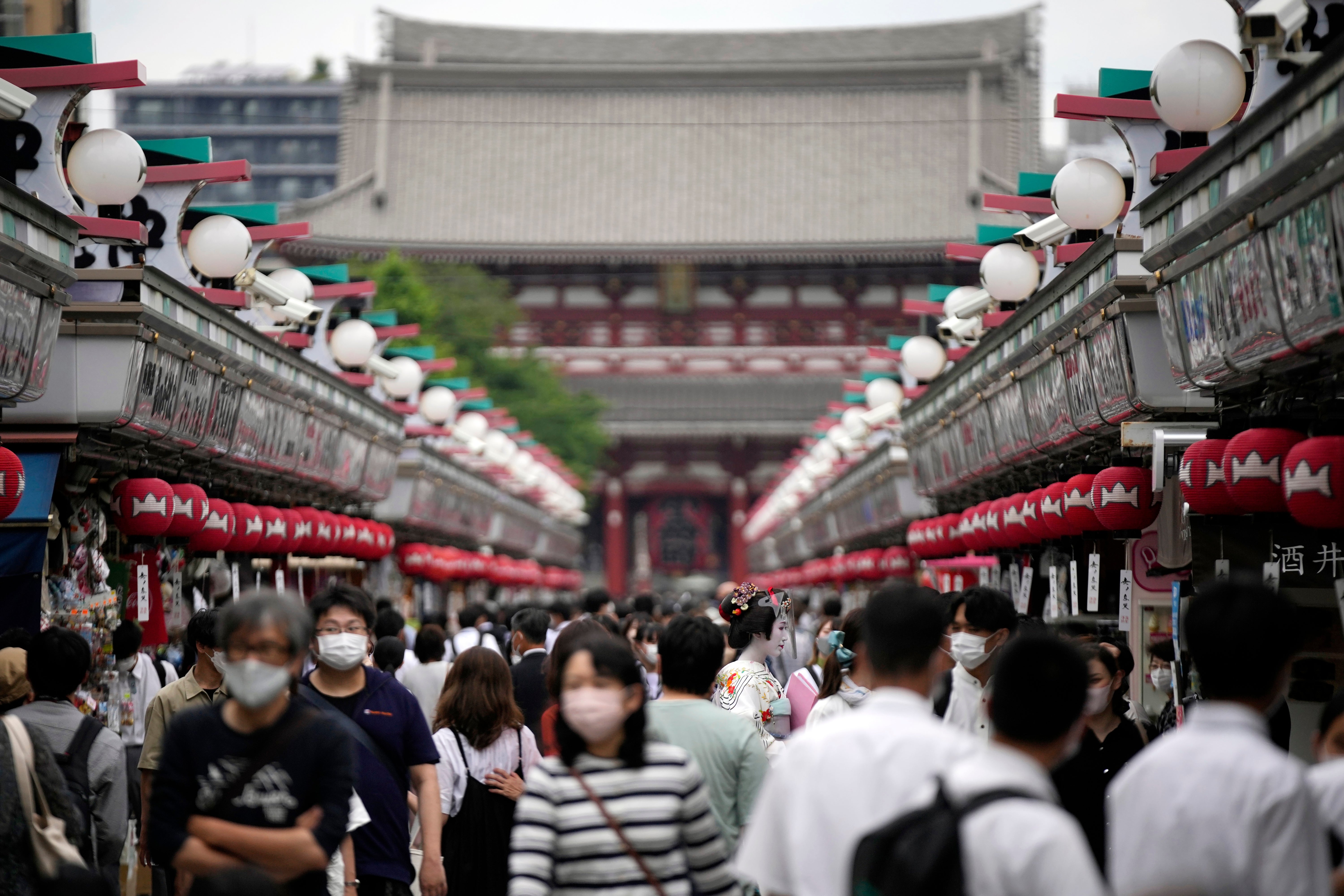 Los visitantes caminan por una calle comercial en el distrito de Asakusa.