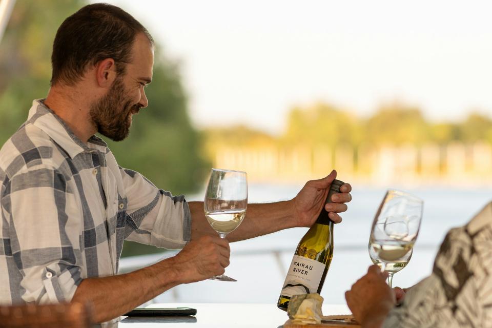 Un hombre mira una botella de vino.