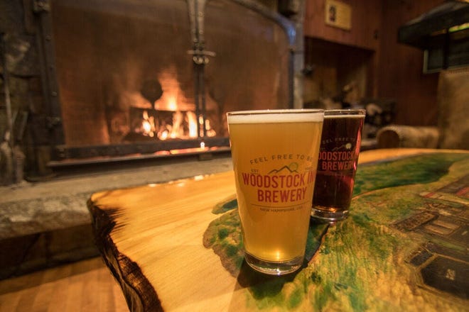 Relájese junto a la chimenea de Woodstock Inn Brewery en New Hampshire.