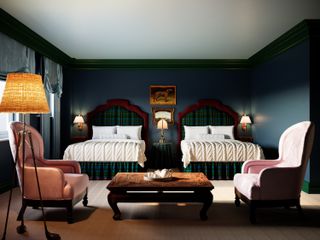 Vista interior de una habitación en Portish Adelphi con una cama individual con cabeceras a cuadros y dos sillas rosas.