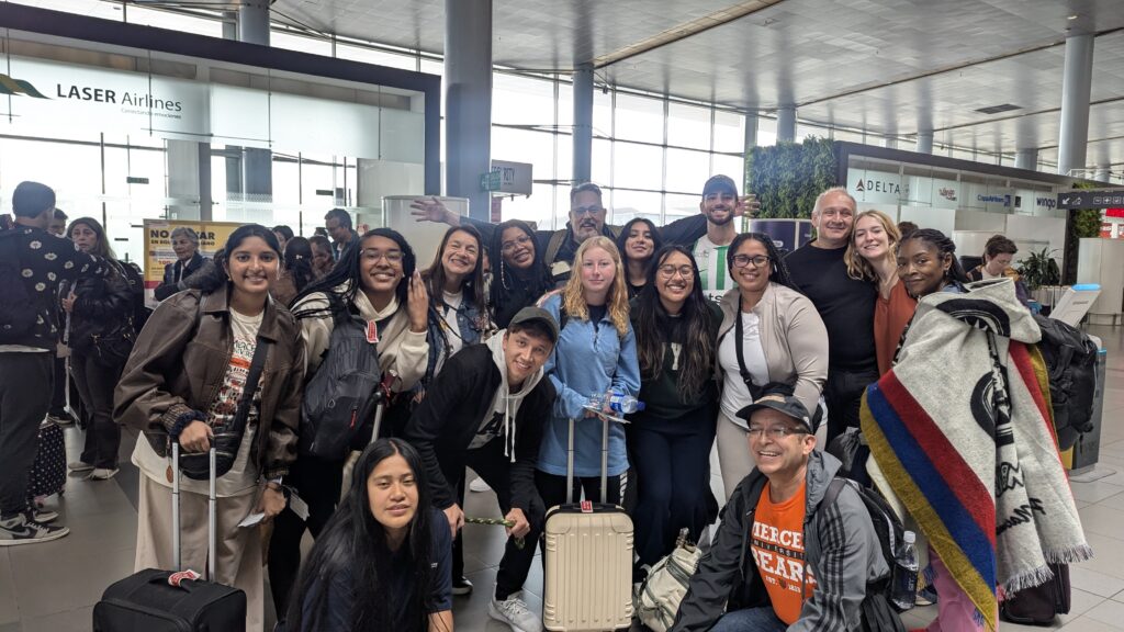Un grupo de personas dentro de la terminal del aeropuerto cerca de la aerolínea cheques en los contadores trae bienes.