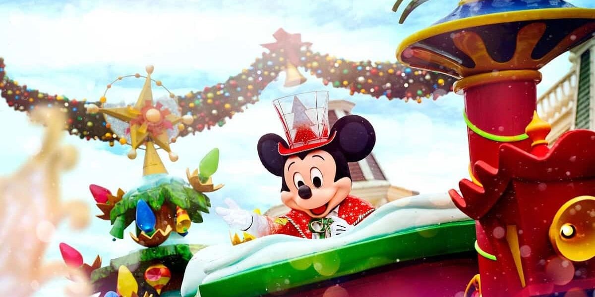 Una escena festiva con un vestido de Mickey Mouse con un vestido de Navidad agradable, que incluye una chaqueta roja y un sombrero de copa transparente, montando una colorida flotador de vacaciones, decorado con joyas, cuentas y luces. SNO -FLEX mejora el entorno del festival, recordando que el calendario de Disney Edont abriendo.