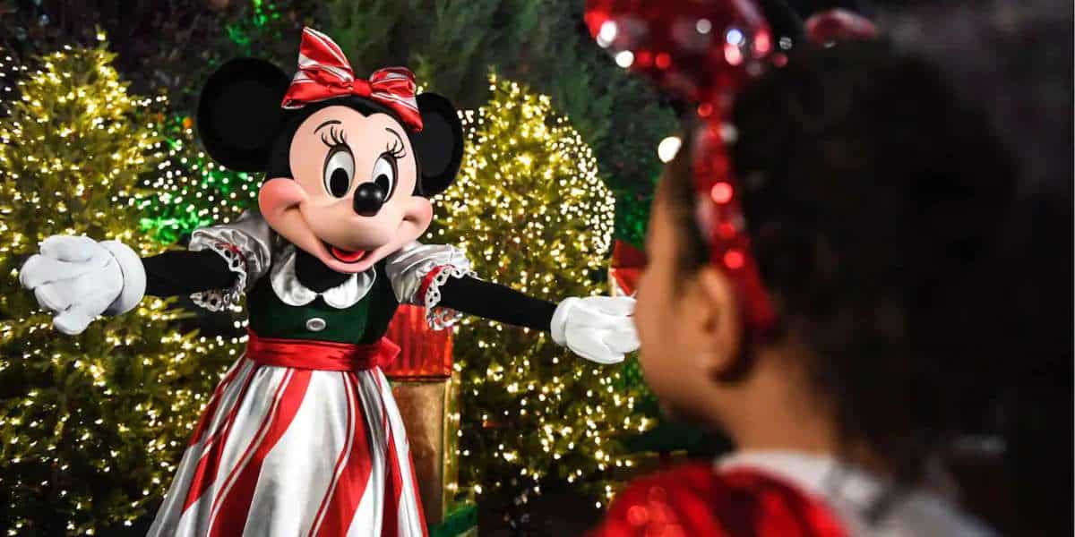 Walt Disney está abrazando un mini ratón con un vestido de Navidad en el World Resort.