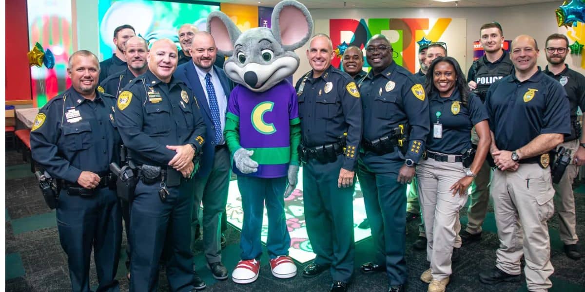 Un grupo de policías y personal dijo pose y sonríe con Shubnkar de Chaki Cheesar dentro de una sala de fiestas de decoración brillante.