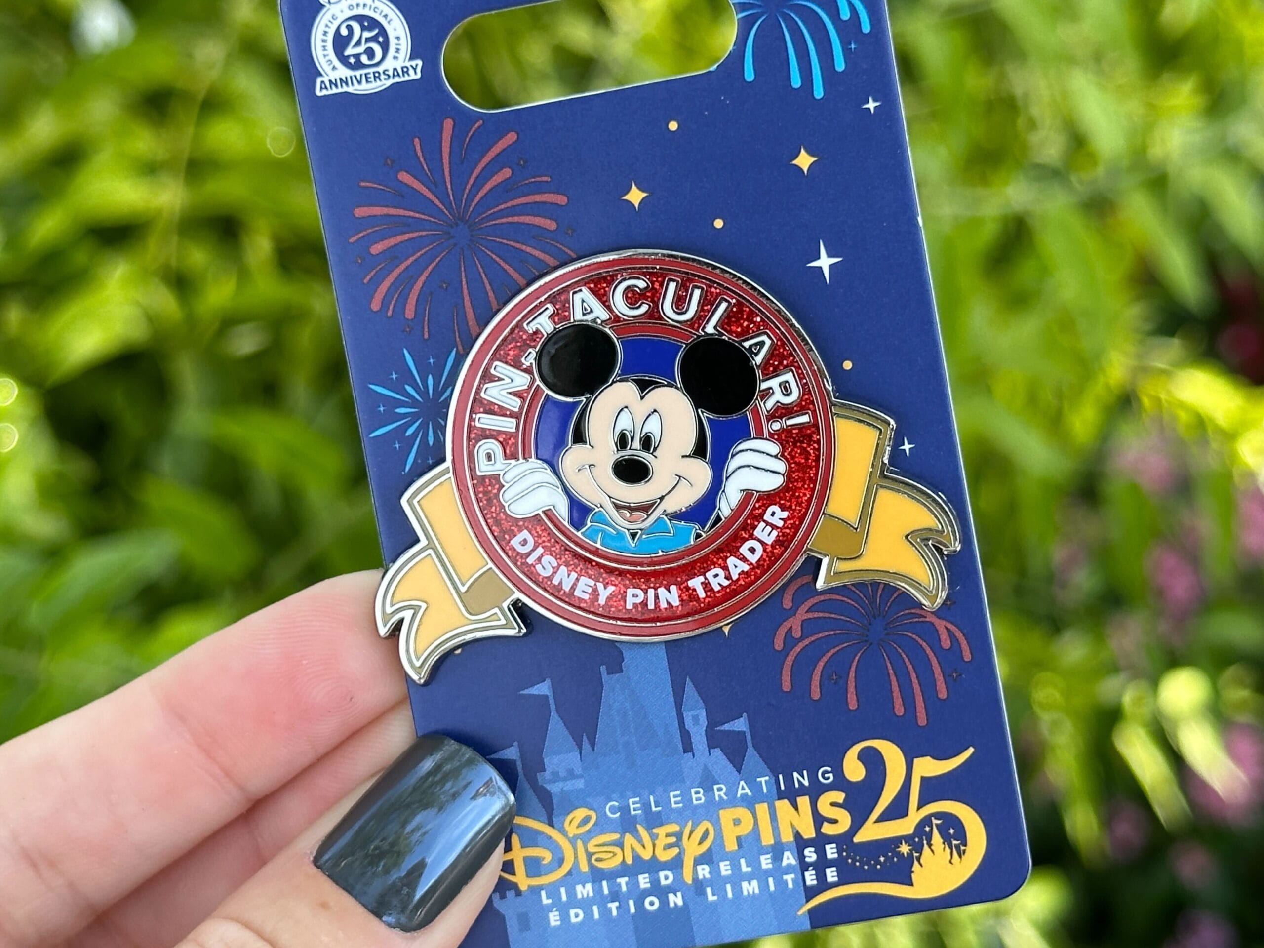 El PIN de Disney World Pin en una mano presenta un Mickey Mouse, que celebra el 25 aniversario de Disney Pins.