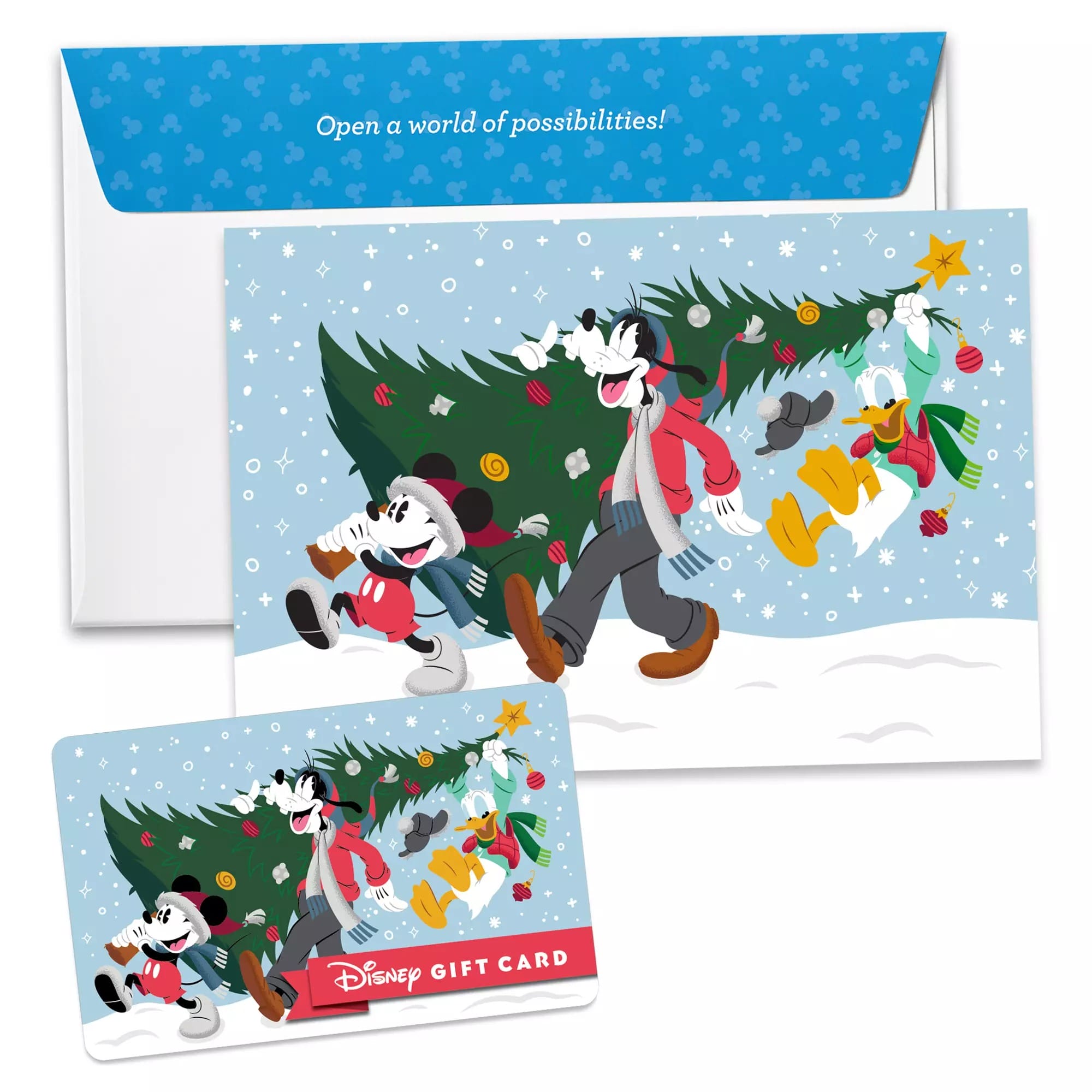 El sobre con tarjetas de regalo de Disney, tarjetas y Mickey, Morha y Donald llevando el árbol de Navidad adornado en la nieve.