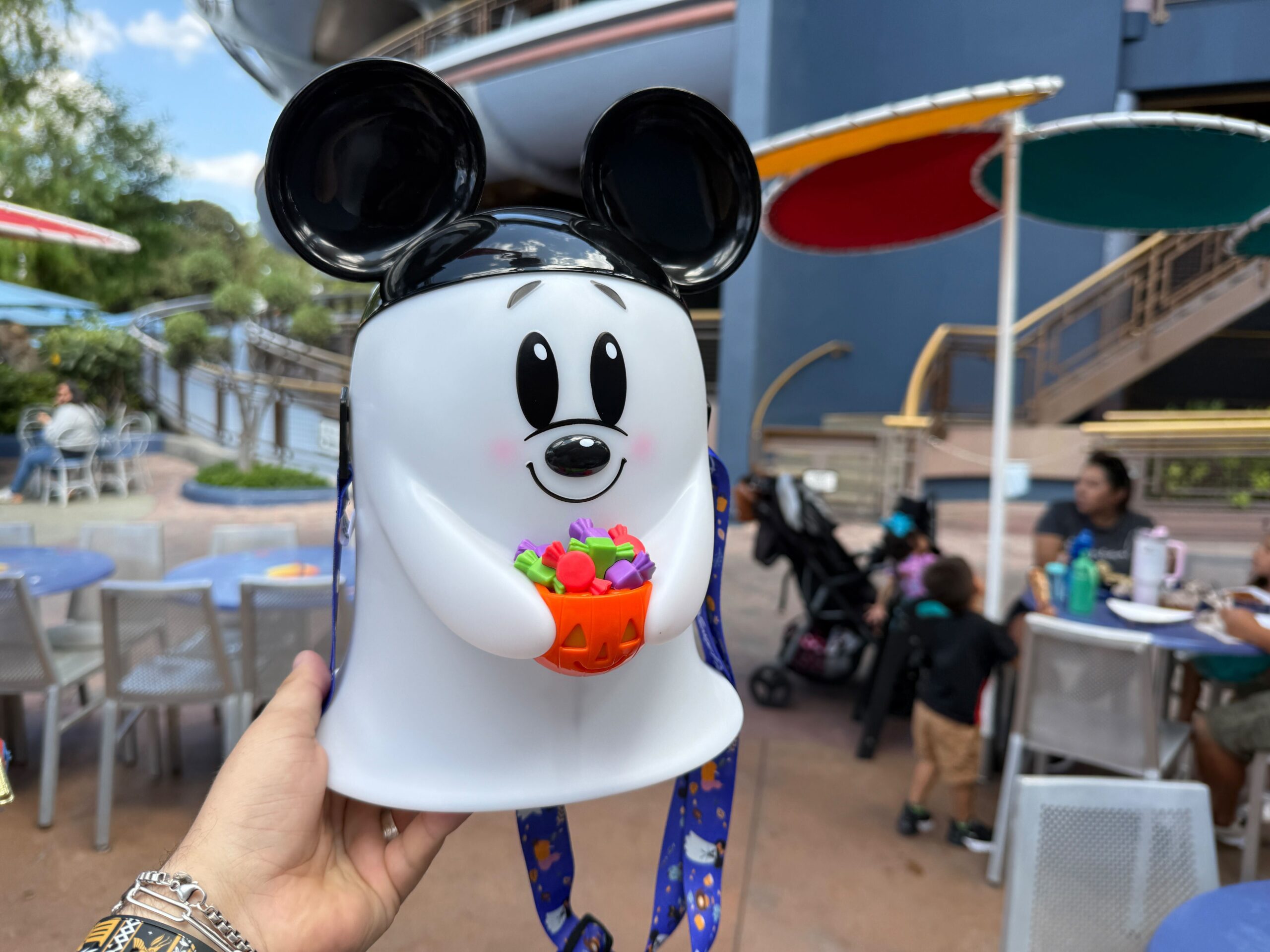 Un hombre con el tema de Halloween en el comedor de Expernyland de Disneyland, contiene el cubo de palomitas de maíz Mickey Ghost 2025.