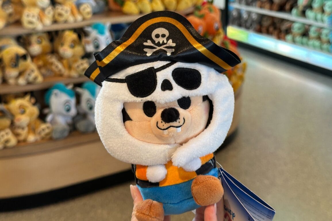 Había un juguete de lujosos piratas en una mano que tiene un parche de sombrero y ojos de cráneo en la tienda Walt Disney World llena de un sombrero de cráneo y un parche de ojos.