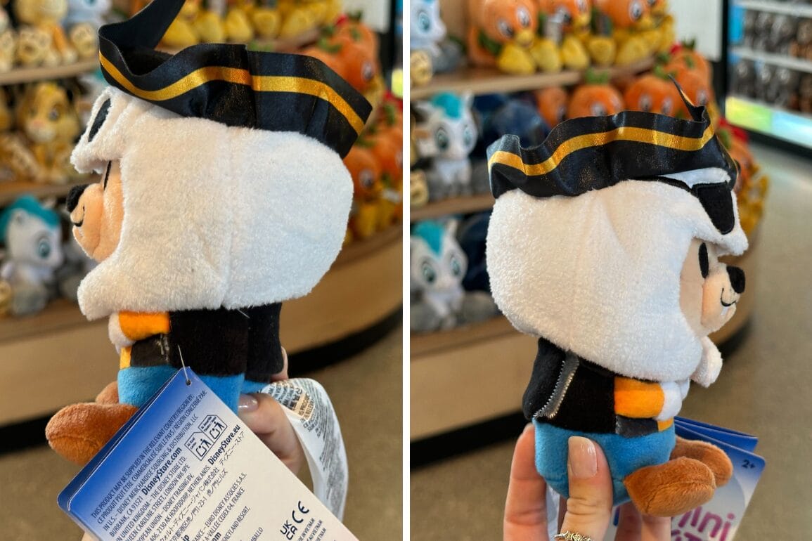 Un hombre sostiene un juguete de lujoso Mickey Mouse, que contiene juguetes de lujo de murmullo en estantes vestidos con una tienda vestida con un ladrón marino.