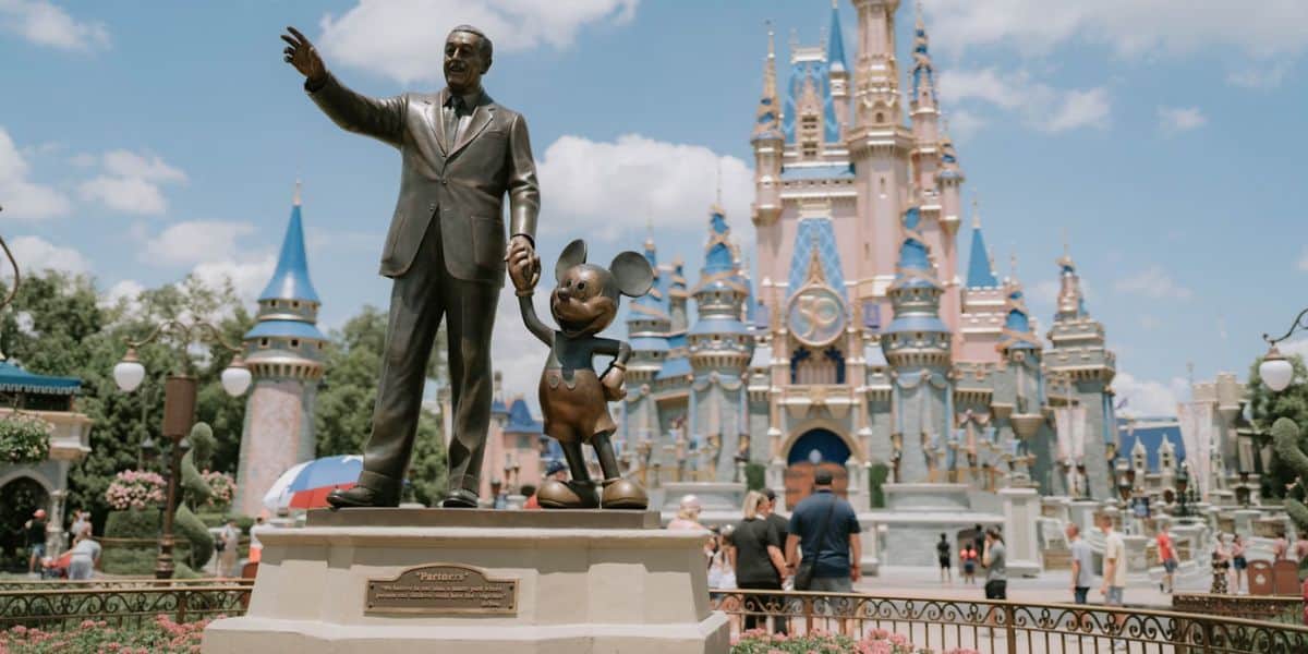 Multitudes cerca de una estatua de socios en el Reino Mágico.