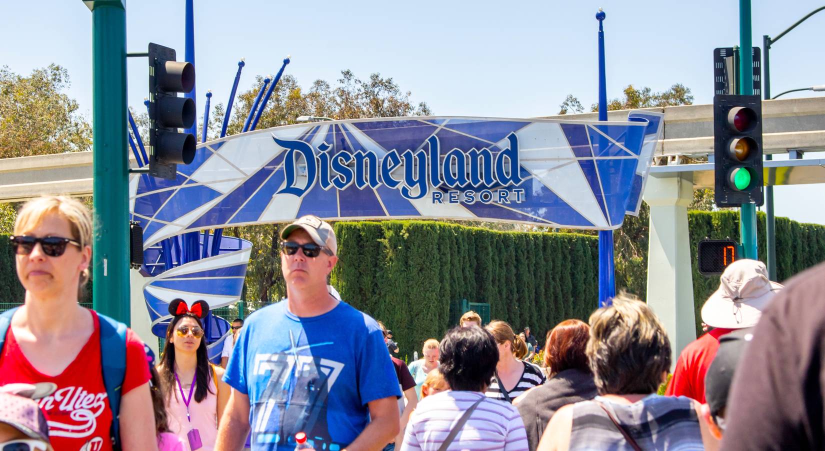 Los turistas cruzan la carretera hacia el parque temático de Disneyland en la ciudad de California de Anham.