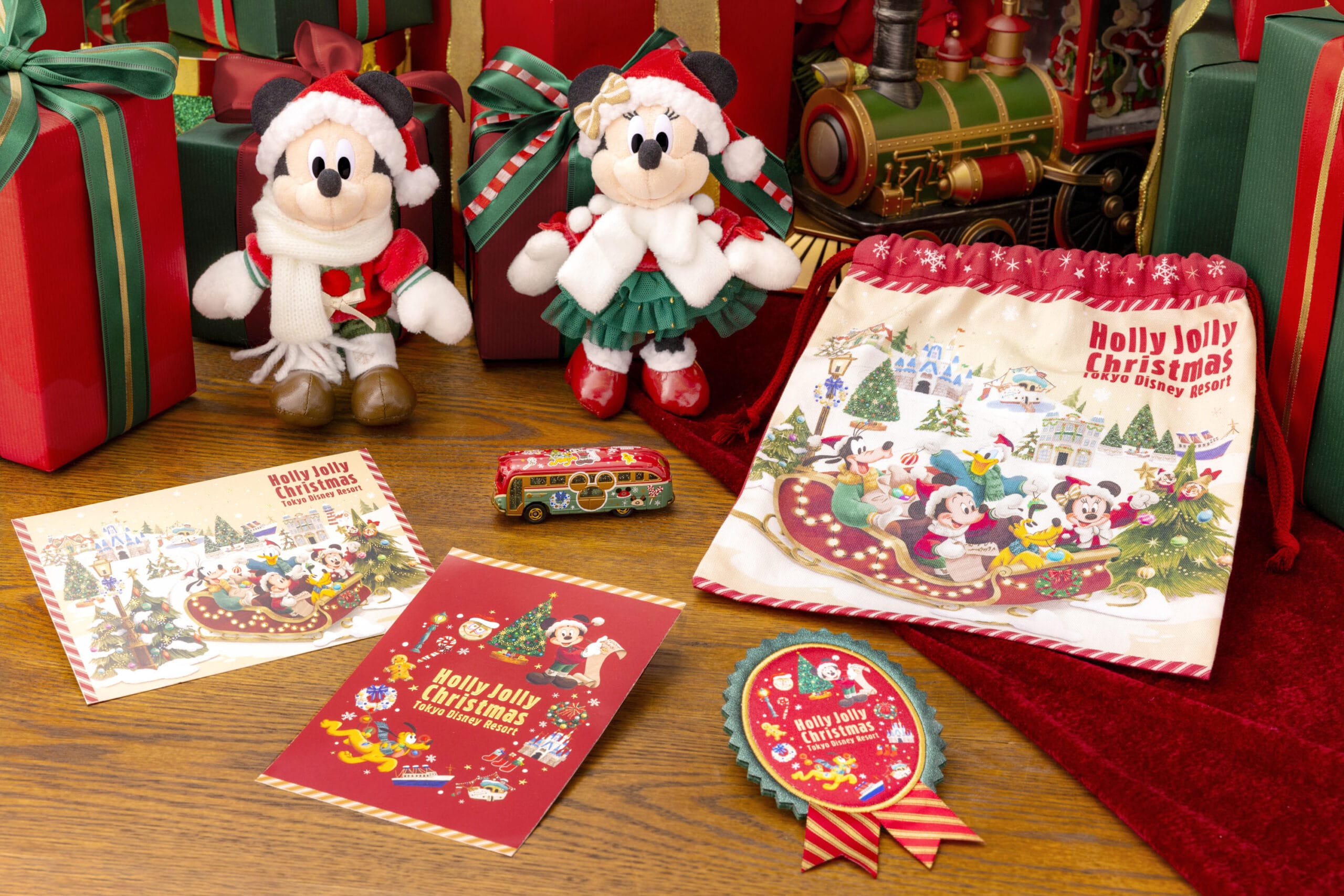Una exhibición festiva de artículos para el desfile de Navidad de Tokio Disneyland, que incluye a Mickey y Mini peluches, postales y un autobús de juguete.