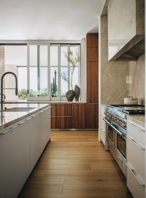 En la cocina, los gabinetes empotrados en nogal macizo y aluminio gris arena combinan maravillosamente con pisos de roble cepillado de madera artesanal. Los electrodomésticos Sub-Zero, Wolf y Cove de última generación completan el diseño refinado pero funcional del espacio.