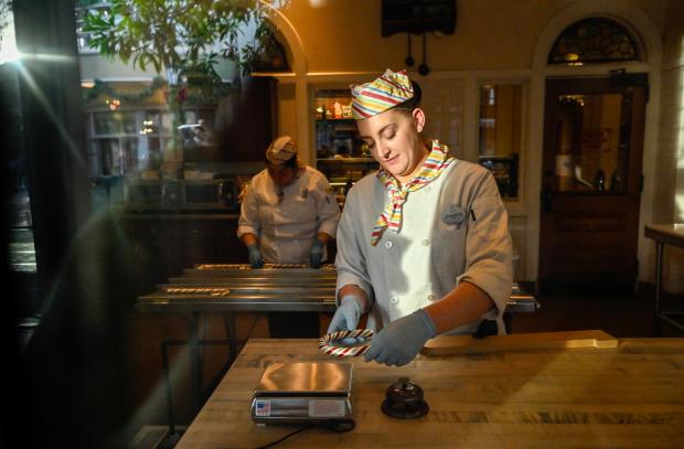 Los fabricantes de dulces crean bastones de caramelo frescos parados con las manos en el carrito de la calle Buena Vista en Disney California Adventure el lunes 11 de diciembre de 2023 en Anaheim, CA. Disney fabrica bastones de caramelo en días selectos en DCA y Disneyland Park. (Foto de Jeff Gerchin, Registro del Condado de Orange/SCNG)