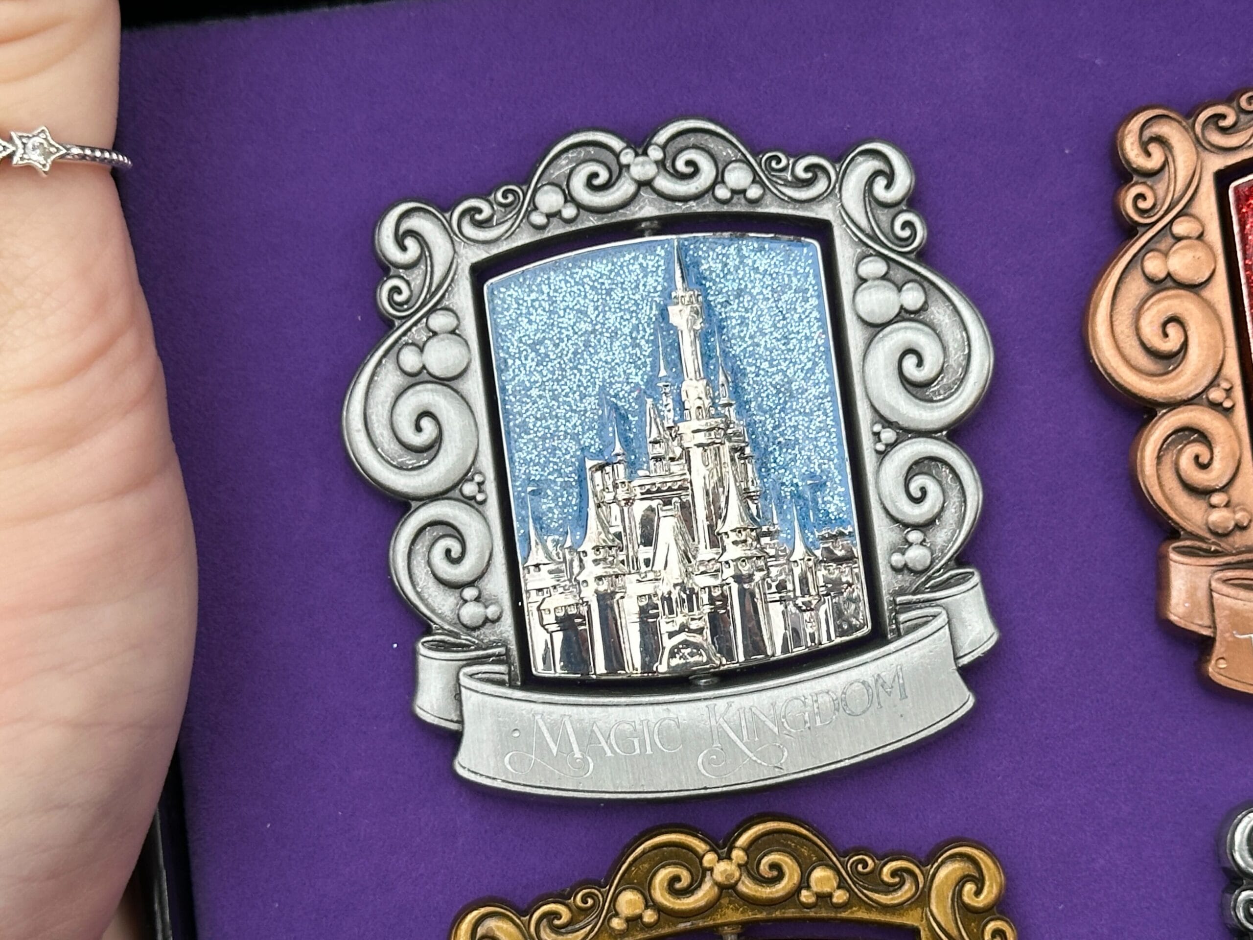 El pin de Magic Kingdom tiene un acabado plateado con el Castillo de Cenicienta sobre un fondo azul brillante. 