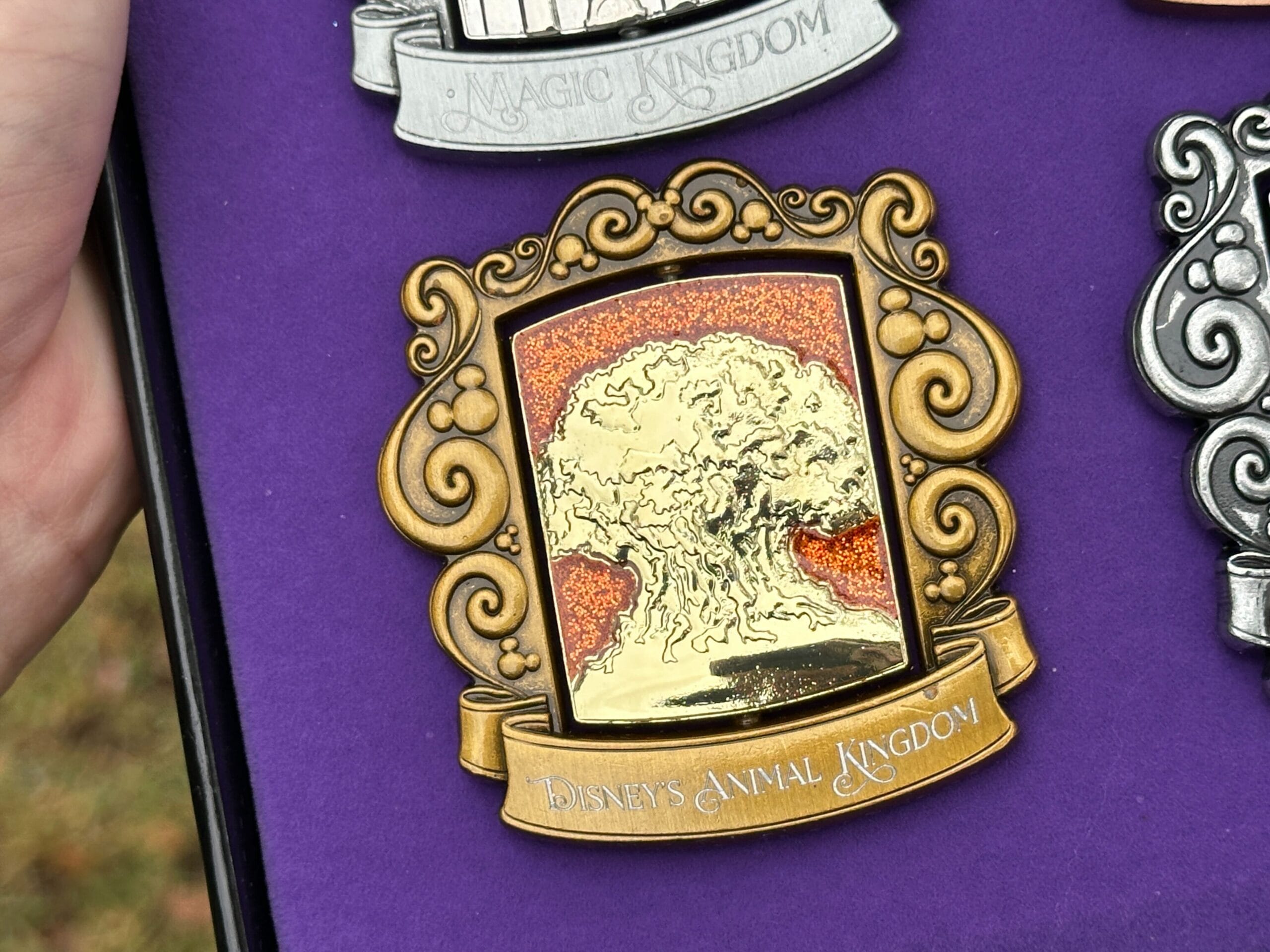 Animal Kingdom de Disney tiene un acabado dorado con el Árbol de la Vida frente a un fondo naranja brillante.