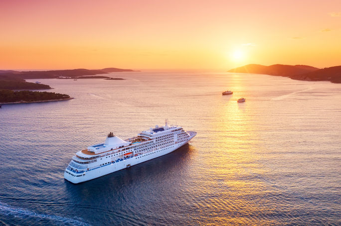 Un crucero navega hacia el atardecer. Un crucero navega hacia el atardecer.