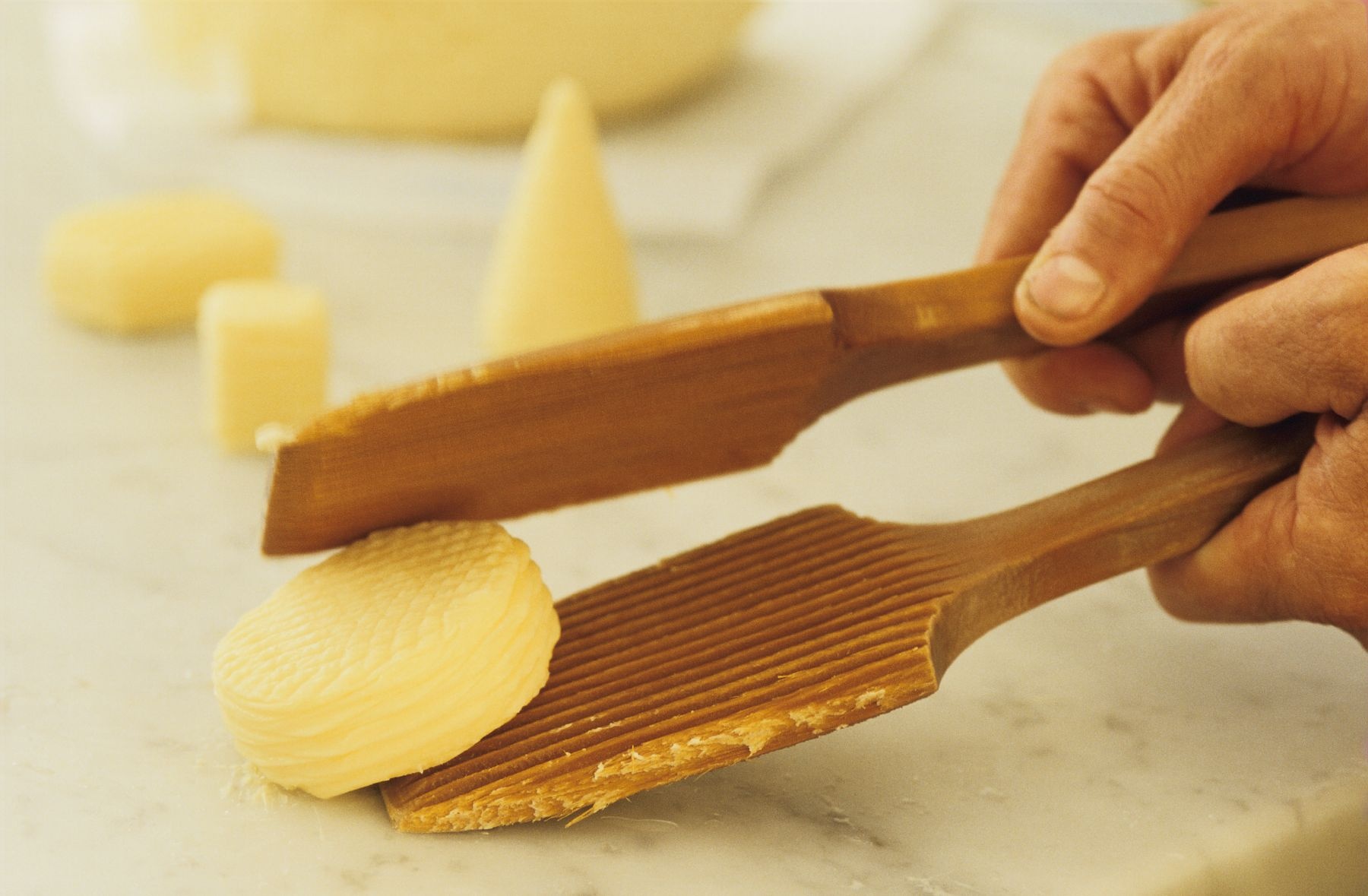 Manos que dan forma a la mantequilla con paletas de madera de La Fromagee en Saint-Malo, Bretaña.