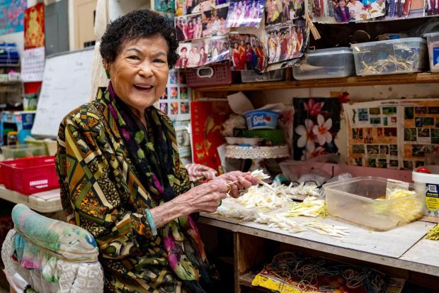 Cindy Lau, propietaria de Cindy's Lee Shop, posa para un retrato en Flowers on a Wire en Chinatown, el jueves 26 de febrero de 2026, en Honolulu. (Foto AP/Mengxin Lin)