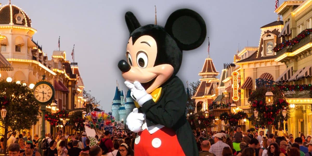 Mickey Mouse da la bienvenida a los visitantes a una animada y festiva calle principal de Disney World rodeada de multitudes festivas en la Navidad de 2025 en Magic Kingdom.
