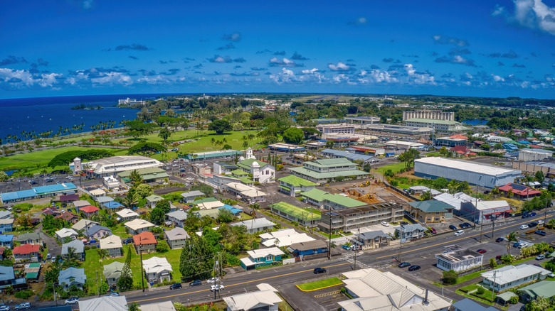 Una vista aérea del centro de Hilo, Hawaii, con edificios residenciales de dos pisos en primer plano y el océano al fondo