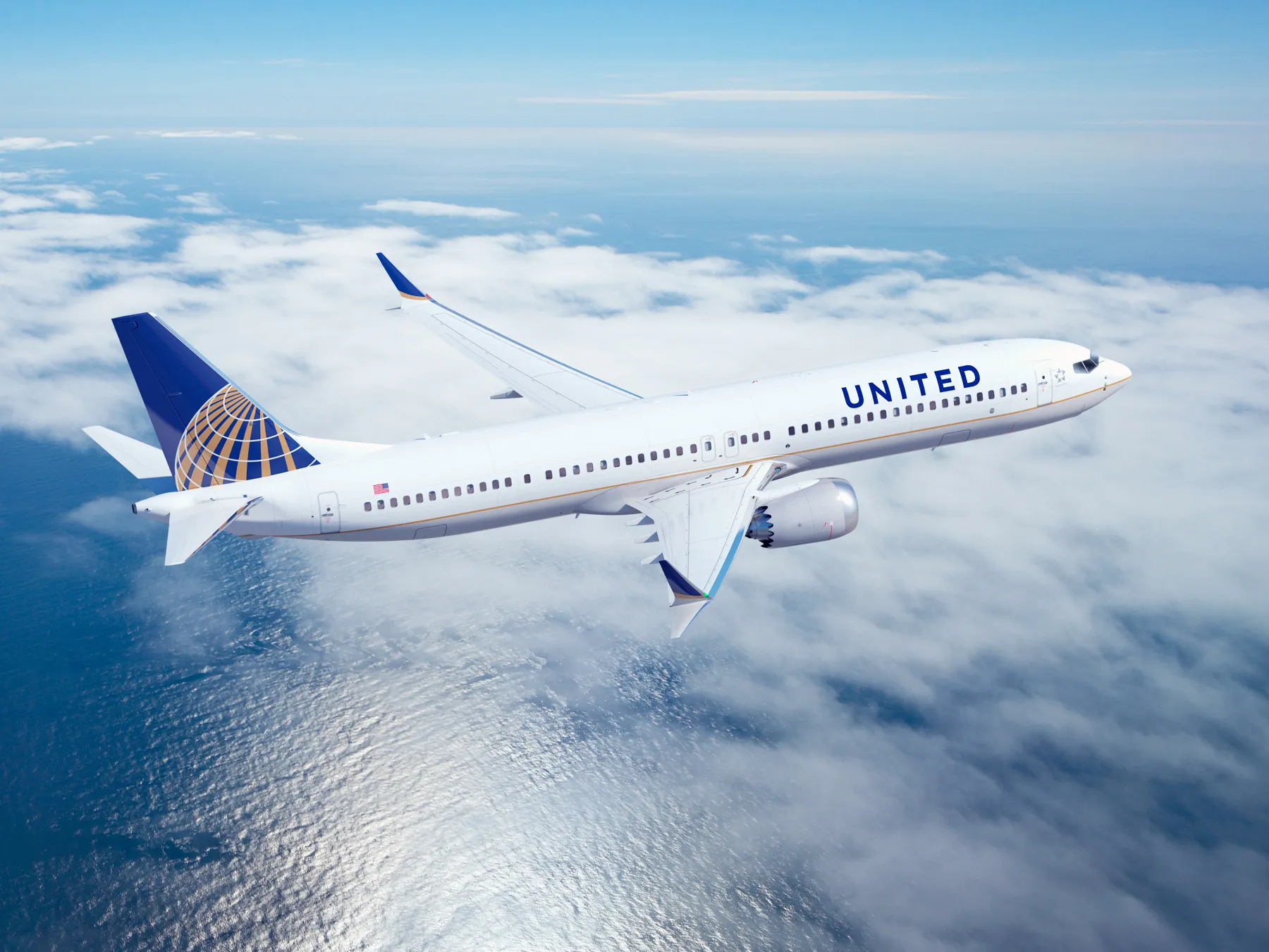 Un avión de United Airlines vuela sobre el agua.