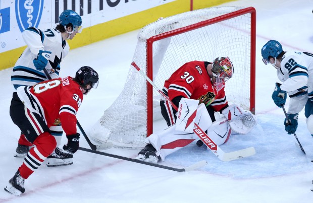 El portero de los Chicago Blackhawks, Spencer Knight (30), no logra detener el disco mientras el centro de los San Jose Sharks, Michael Mesa (izquierda), anota durante el segundo período de un juego en el United Center en Chicago, el 15 de abril de 2026. (Chris Sweda/Chicago Tribune)