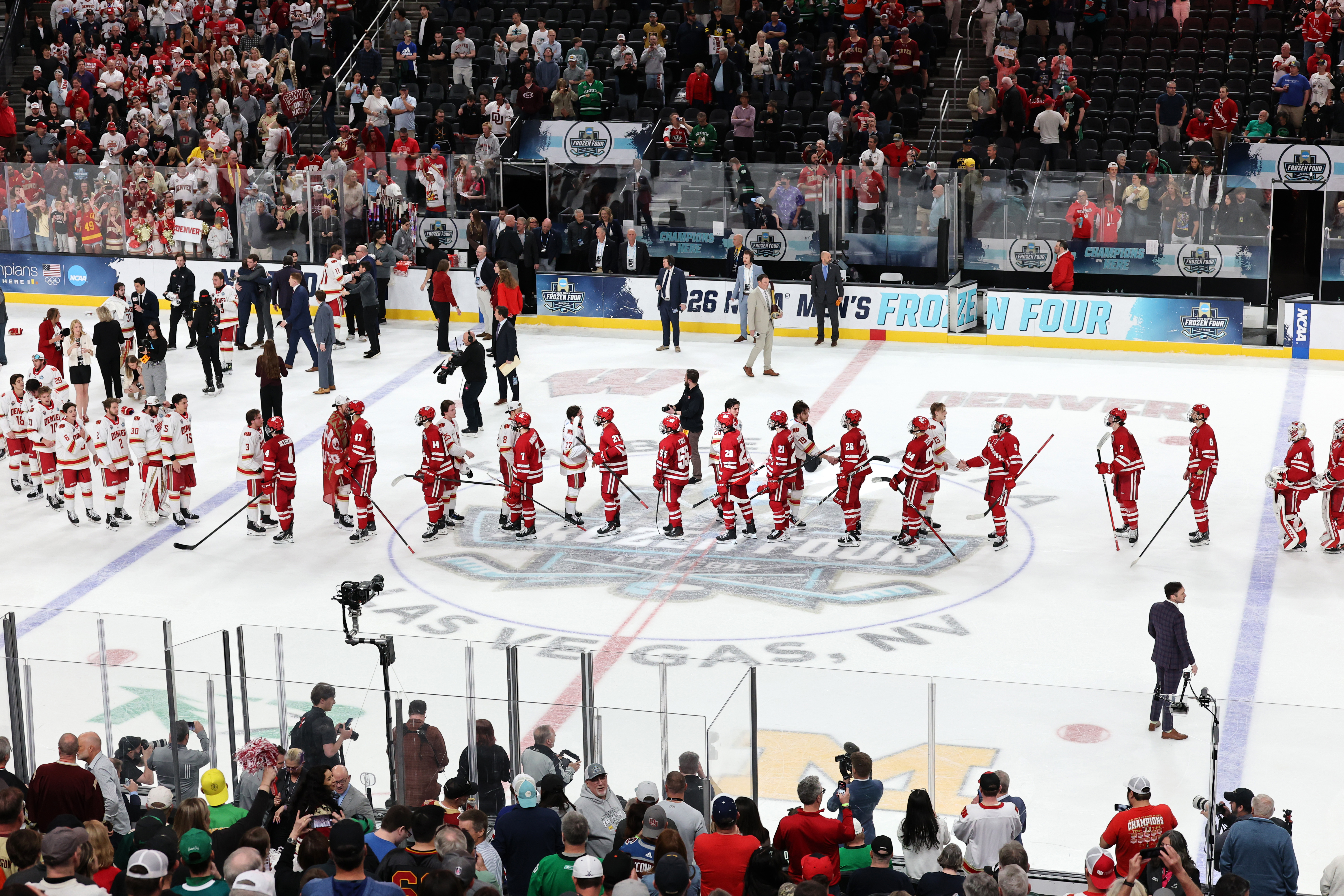 Los miembros de los Denver Pioneers y los Wisconsin Badgers se dan la mano...
