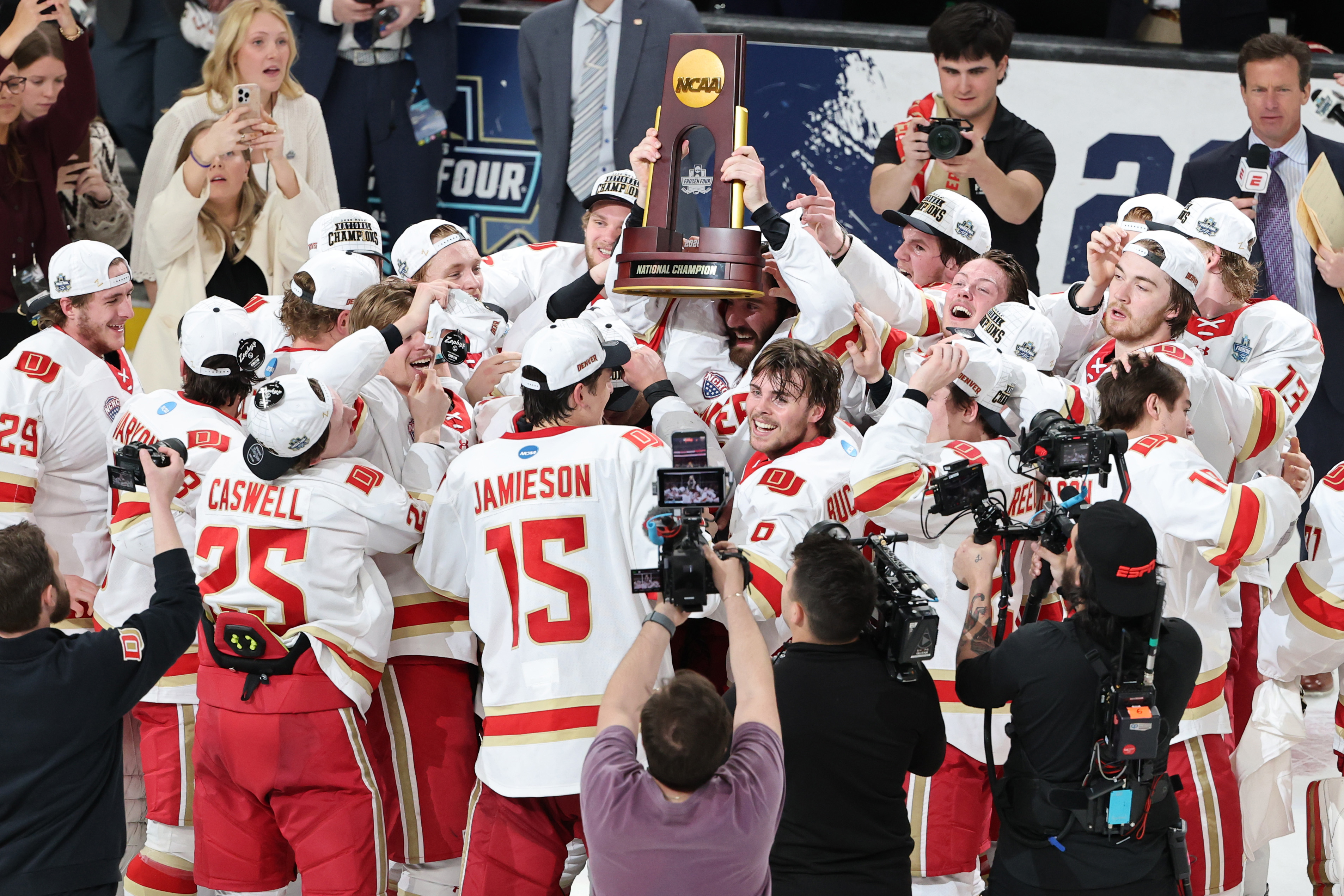 Los miembros de los Denver Pioneers celebran con el trofeo...