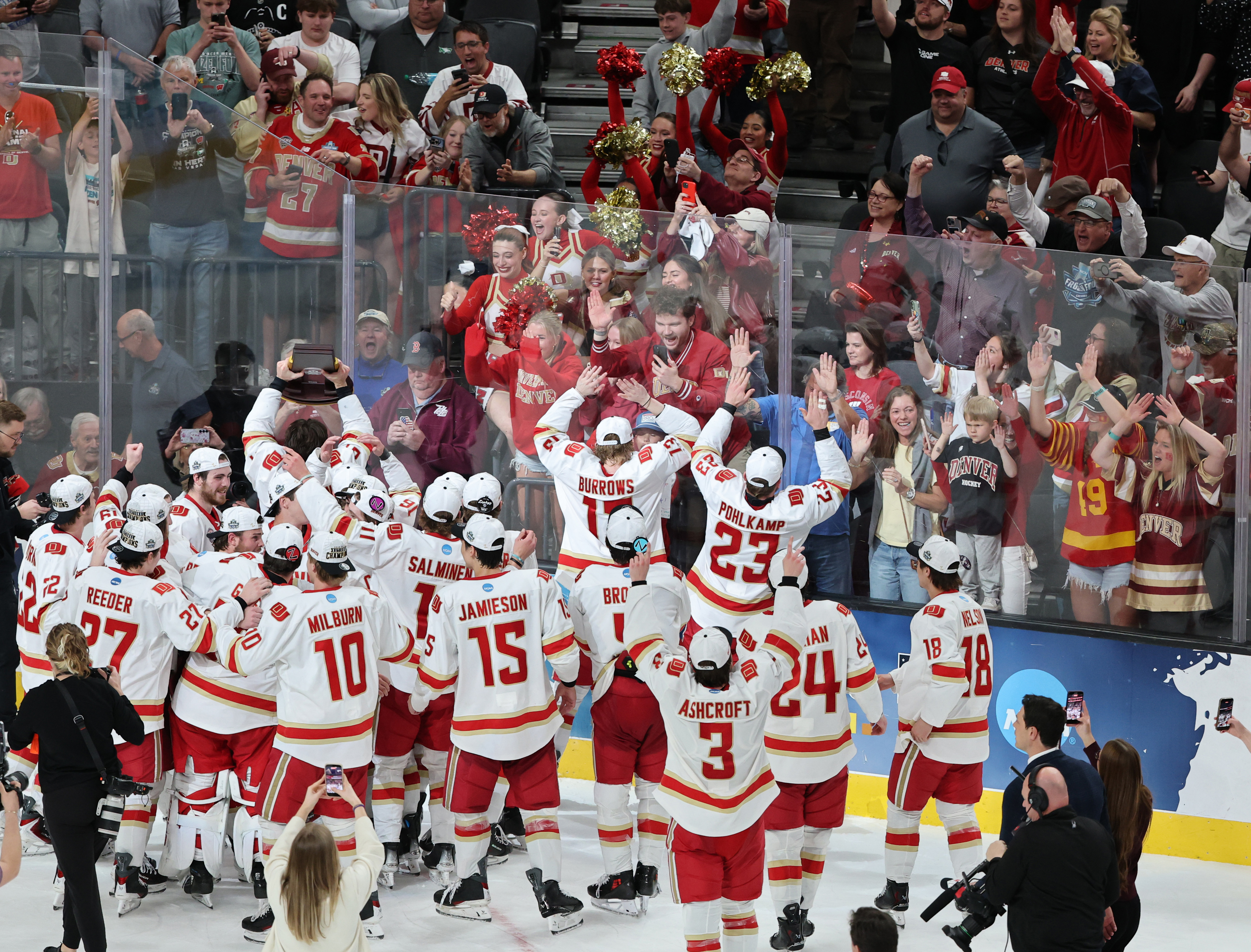 Los miembros de los Denver Pioneers celebran con sus fanáticos...
