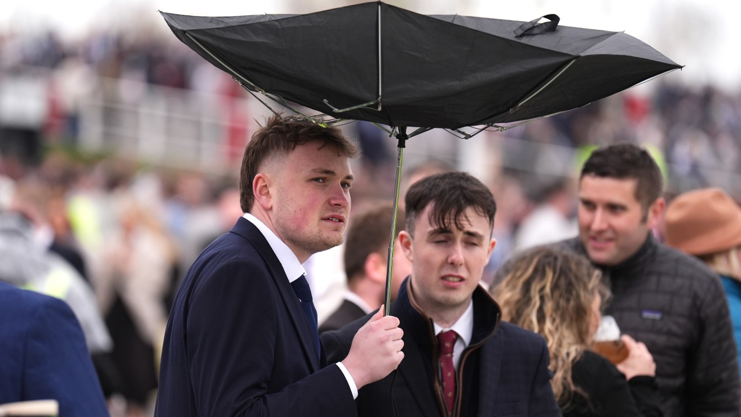 Un chivo expiatorio sostiene un paraguas el Gran Día Nacional en el Gran Festival Nacional Randex 2026 en el hipódromo de Aintree.